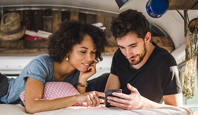 A man and a woman looking at a mobile phone